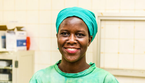 Gladys Atto in her doctor's uniform, smiling at the camera.