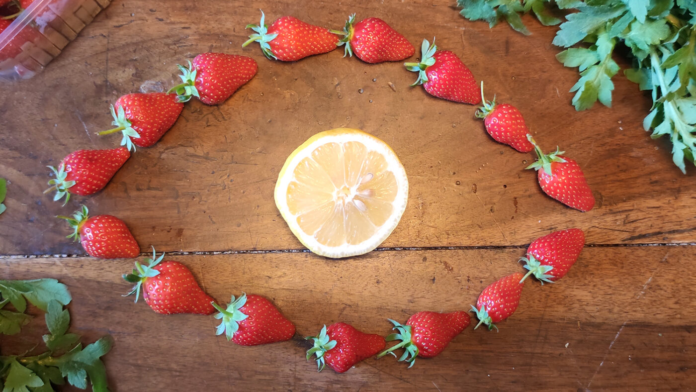 Stawberries and lemon in an eye shape.